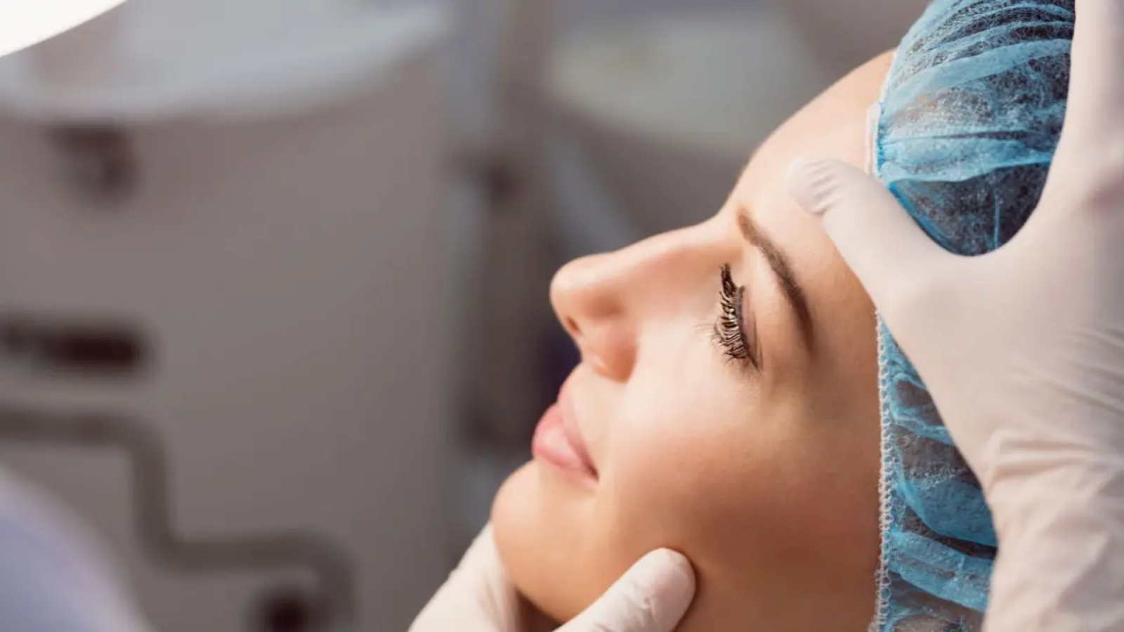 Un miembro del equipo del Dr Mayo revisa a una paciente que se acaba de someter a una rinoplastia funcional en A Coruña