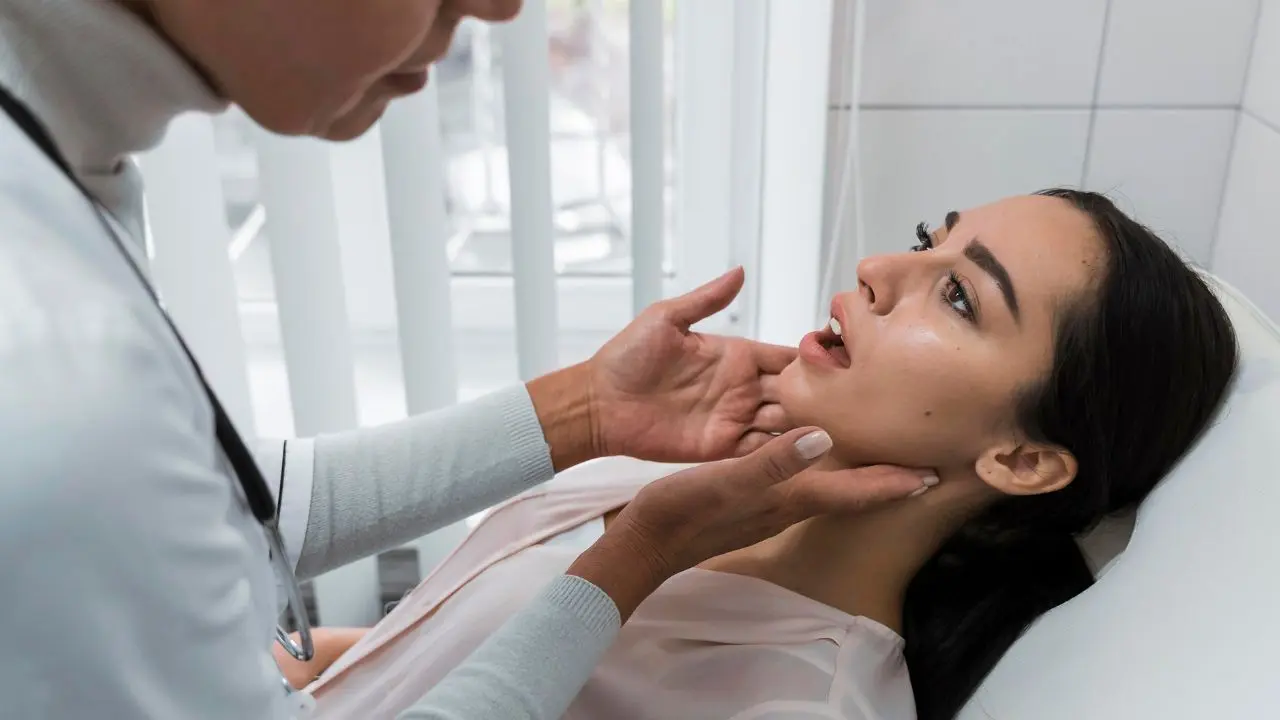 Un otorrino explora a una paciente que padece de amigdalitis recurrente