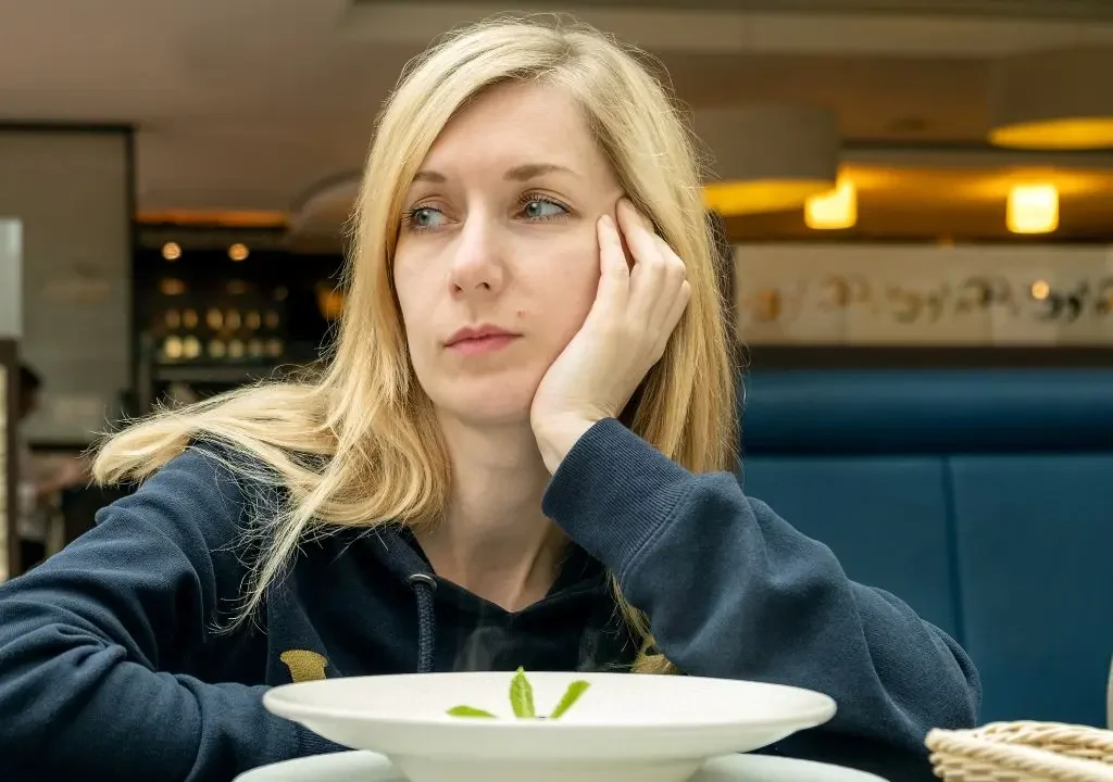 Vista de una mujer con misofonía en la mesa de un restaurante