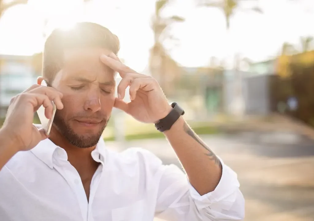 Un hombre padece un vértigo por calor mientras habla por teléfono