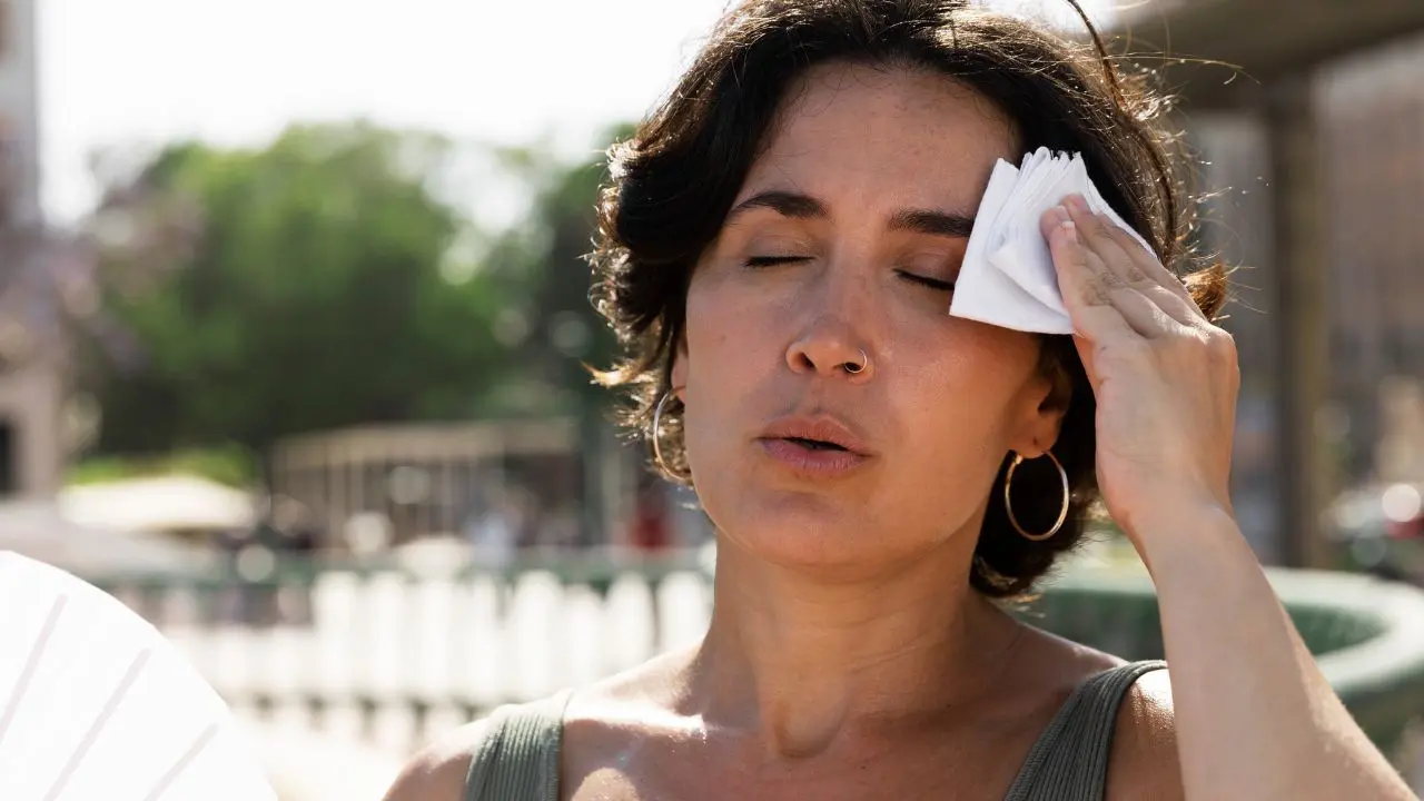 Vista de una mujer que acaba de padecer un vértigo por calor en plena calle
